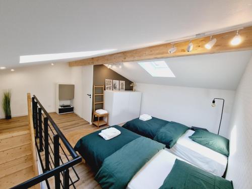 - un salon avec un canapé et des oreillers verts dans l'établissement Dépendance cosy en duplex avec terrasse & jardin, à Valleiry
