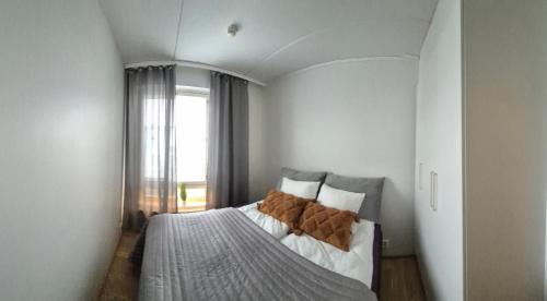 a bedroom with a large bed with a window at TAMPERE PENTHOUSE-tasokas moderni kaupunki huoneisto huipulla -ISO JACUZZI omalla KATTOTERASSILLA - AURINKOTUOLIT ja Aurinko odottaa Sinua - huikea maisema- - 10 HLÖ - free parking in Tampere