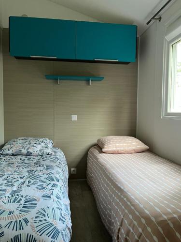 une petite chambre avec un lit et une armoire dans l'établissement Mobilhome Mag Ced les Dunes de contis Piscines et Plage, à Saint-Julien-en-Born