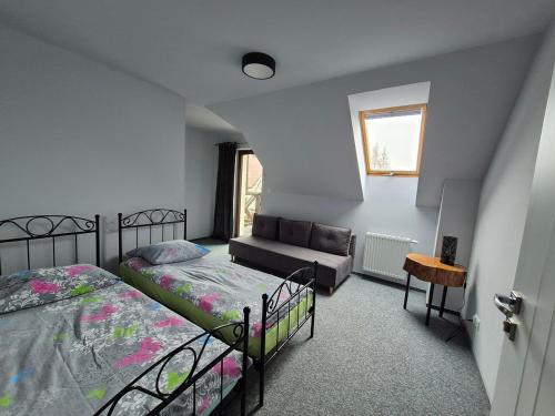 a bedroom with two beds and a couch in it at GOSPODARSTWO TURYSTYCZNE w OSINKACH in Suwałki