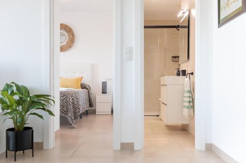 a hallway with a bedroom with a bed and a plant at Casa Ilusión in Frigiliana