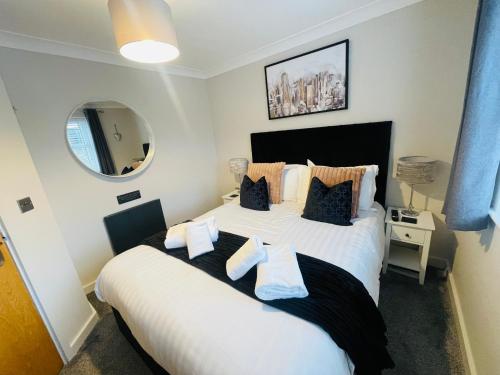une chambre avec un grand lit blanc avec des oreillers dans l'établissement The Mowbray, à Harrogate