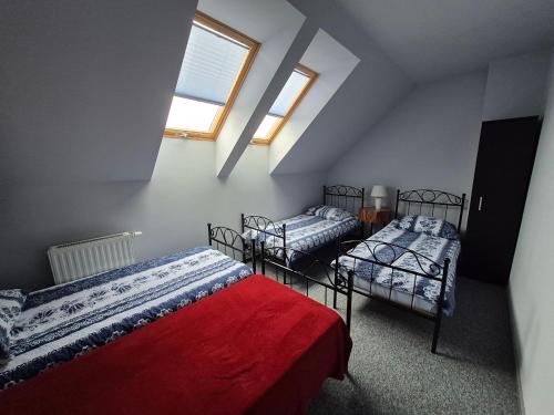 a attic room with three beds and a window at GOSPODARSTWO TURYSTYCZNE w OSINKACH in Suwałki