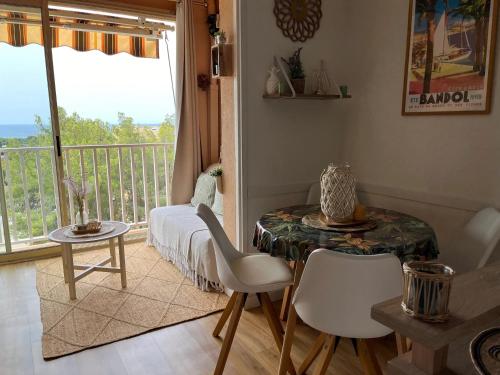 ein Wohnzimmer mit Tisch und Balkon in der Unterkunft Appartement charmant à Bandol 30 m² avec vue sur la mer. in Bandol