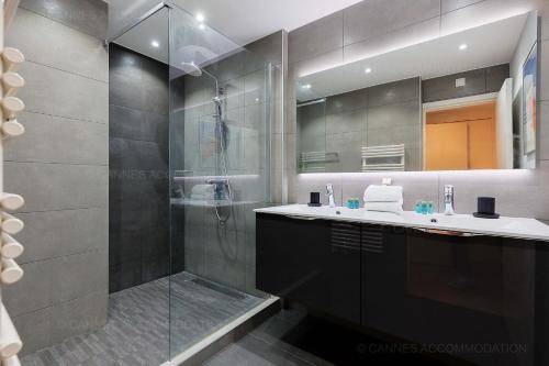une salle de bain avec une douche, un lavabo et un miroir dans l'établissement Gray 2A2, à Cannes