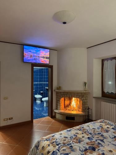 a bedroom with a fireplace with a tv on the wall at Villa dei Macchini in Chiusi della Verna