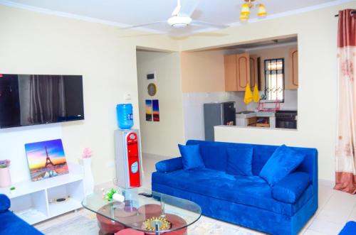 a living room with a blue couch and a glass table at Lifestyle furnished 2 bedroom Mtwapa in Mombasa
