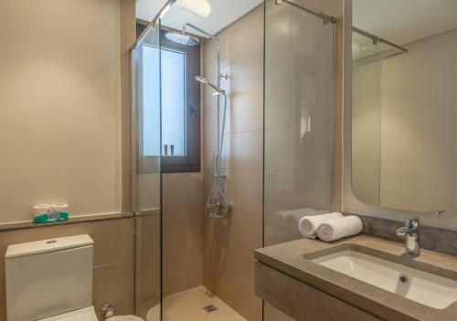 a bathroom with a glass shower and a sink at Ancient Hill 3BR Gouna Sea View & Priv Roof Pool in El Gouna