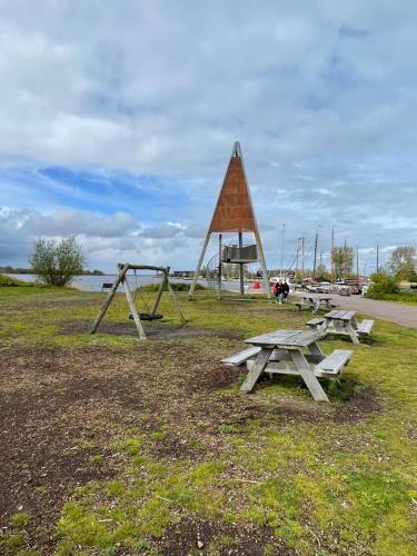 a group of picnic tables in a park at Low Budget - Luxe 4 persoons chalet met TV aan het Lauwersmeer in Lauwersoog