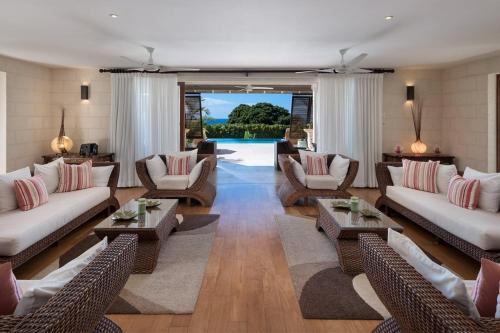 a living room with couches and tables and a patio at Tom Tom 4 bed villa in Saint James