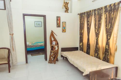 a small bedroom with a bed and a mirror at Mimo's in Guwahati