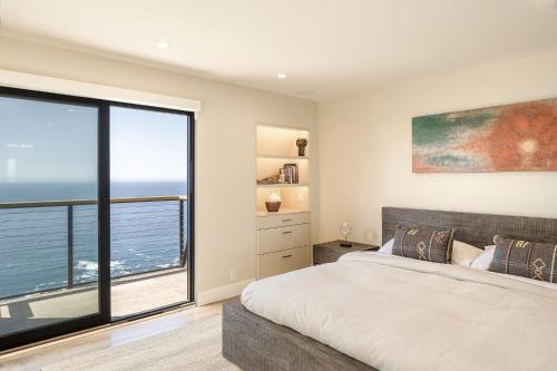 a bedroom with a bed and a large window at 3921 Eyas, Big Sur home in Notleys Landing