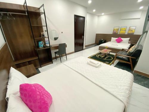 a hotel room with two beds and a desk at B&K Homestay - Glocery Store in Phu Quoc