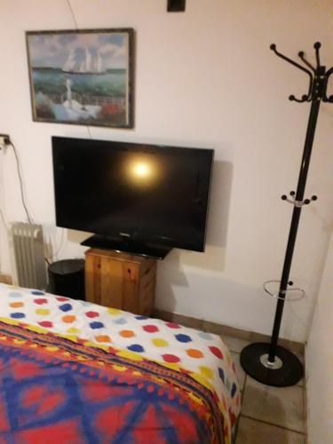 a bedroom with a flat screen tv and a bed at Chambre 4 in Bouc-Bel-Air