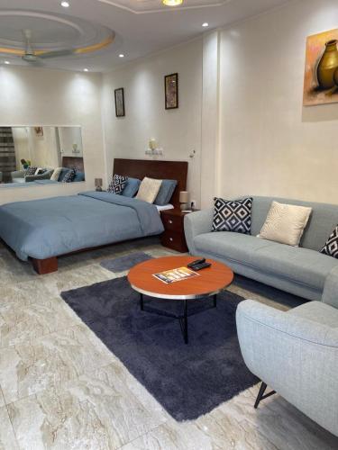 a living room with two beds and a couch and a table at Gilles Golden Palace in Abomey-Calavi
