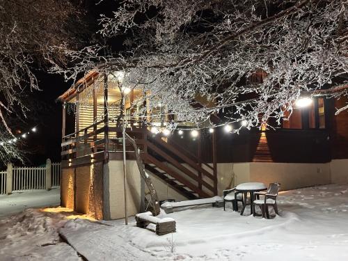 a house with a table and chairs in the snow at Cozy Wooden House in Kiket'i კიკეთი in Kiketʼi