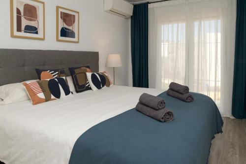 una camera da letto con un letto grande con asciugamani sopra di Casa De Levante - Adosado 3 Habitaciones - By Tarifa Rent a Tarifa