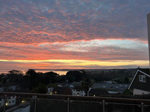 a sunset over a city with houses and buildings at Luxury 3 bedded room with sea peeps and parking in Paignton