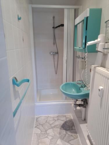 a bathroom with a green sink and a shower at Hotel Pension zur Tanne in Zwickau
