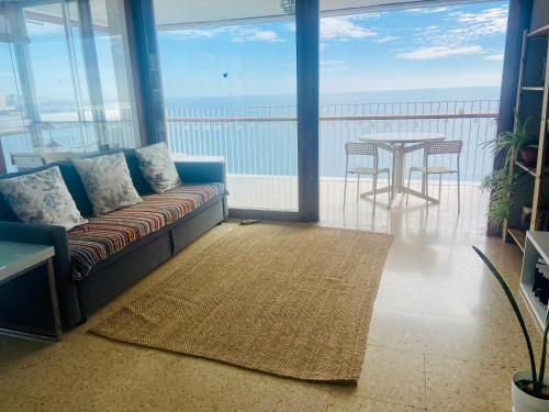 una sala de estar con un sofá y una mesa en Apartamento Torre Alacant, en Alicante