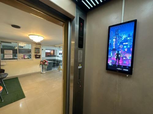 a flat screen tv on the wall of a room at Aomsin Premium Hotel Suit Near Shoping Malls in Ban Lam Rua Taek