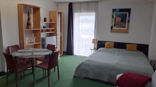 ein Schlafzimmer mit einem Bett und einem Tisch und Stühlen in der Unterkunft Central City 2 Apartman in Debrecen