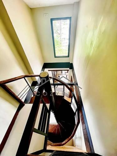 a spiral staircase in a building with a window at CozyPine Homestay in Baguio