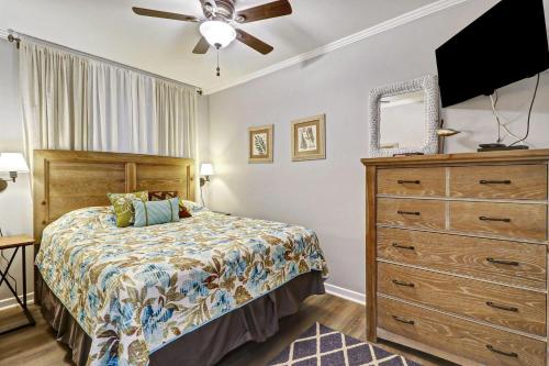 ein Schlafzimmer mit einem Bett und einer Kommode in der Unterkunft Seaside Villa 325 in Hilton Head Island
