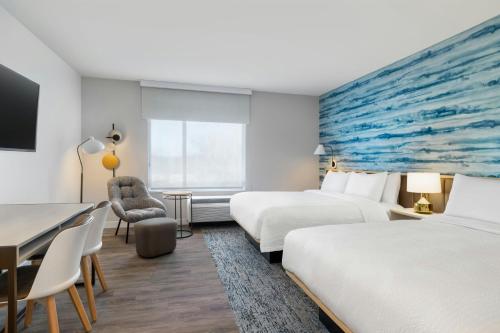 a hotel room with two beds and a desk at TownePlace Suites by Marriott Geneva at SPIRE Academy in Geneva