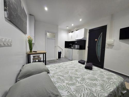 une chambre avec un grand lit et une cuisine dans l'établissement STUDIO COSY Meulan En Yveline, à Meulan-en-Yvelines