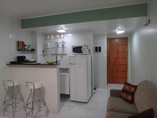 a small kitchen with a white refrigerator and a counter at Ajuricaba Suites 1 in Manaus