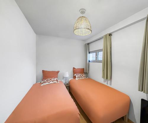 two beds in a room with a window at Charmant T3 lumineux & cosy in Pomponne