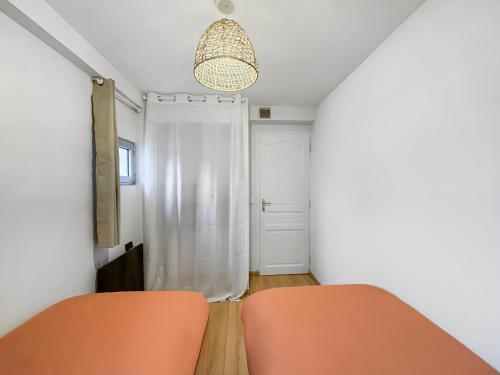 an orange chair in a room with a door at Charmant T3 lumineux & cosy in Pomponne