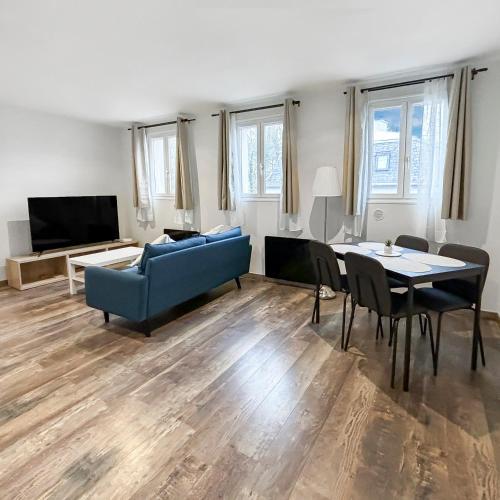 a living room with a blue couch and a table at Charmant T3 lumineux & cosy in Pomponne