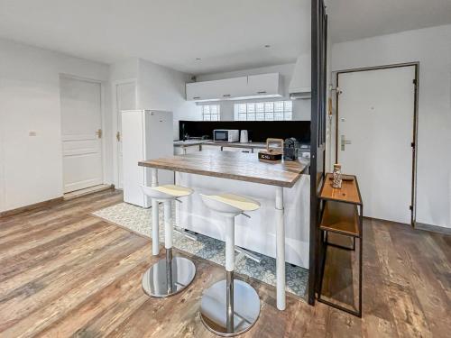 a kitchen with a counter and stools in a room at Charmant T3 lumineux & cosy in Pomponne