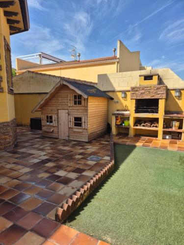 a large patio with a house with a building at Casa Las 7 Maravillas in Fuentidueña de Tajo