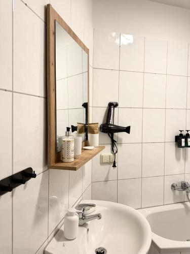 a bathroom with a sink and a mirror at NewCityHome - Dresden - 3 Zi - Garden Apartment Flora - Urban in Dresden