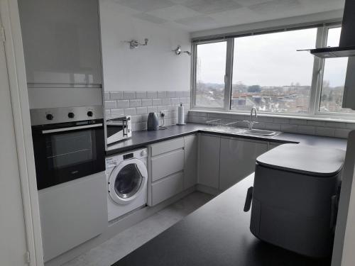 a kitchen with a washing machine and a sink at Magnolia Penthouse in Windsor