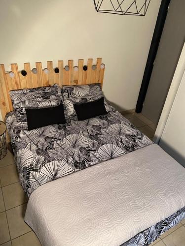 - un lit avec des draps et des oreillers en noir et blanc dans l'établissement Villa Paxia, à Azur