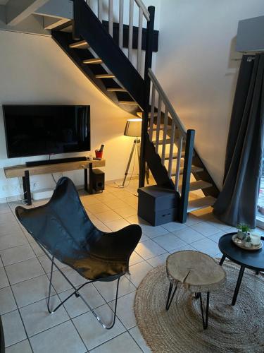 - un salon avec une télévision, une chaise et une table dans l'établissement Villa Paxia, à Azur