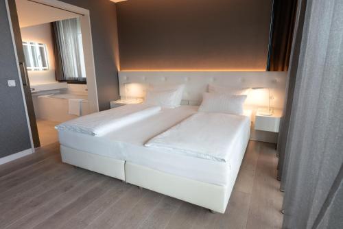 a bedroom with a large white bed with two pillows at Jaz in the City Stuttgart in Stuttgart