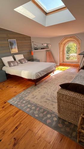 une chambre avec un grand lit et une fenêtre dans l'établissement Maison Girondine au milieu des vignes du Château d Yquem avec belle vue, à Preignac