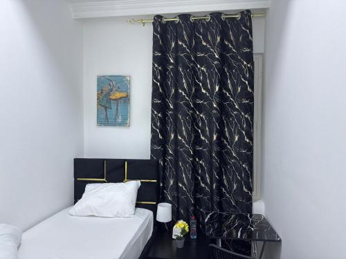 a bedroom with a bed and a black curtain at Four Stars Residence in Dubai