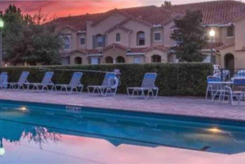 a group of chairs and a pool in front of a house at Home Near Disney Private Pool & Playground in Howey in the Hills