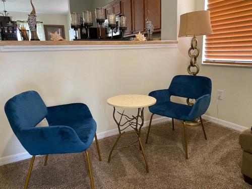 two blue chairs and a table in a room at Home Near Disney Private Pool & Playground in Howey in the Hills