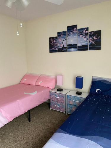 a bedroom with a pink bed and two night stands at Home Near Disney Private Pool & Playground in Howey in the Hills