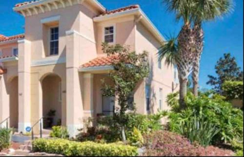a large house with a palm tree in front of it at Home Near Disney Private Pool & Playground in Howey in the Hills