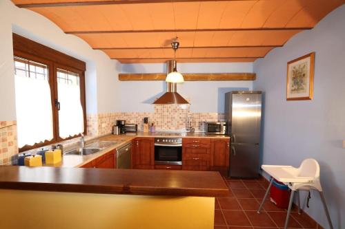 eine Küche mit Holzschränken und einem Edelstahlkühlschrank in der Unterkunft Casa rural San Felices in San Felices de Castillería