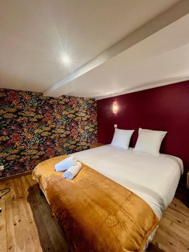 - une chambre avec un grand lit et une fresque murale dans l'établissement l'Evasion avec parking privé, à Bourgoin-Jallieu