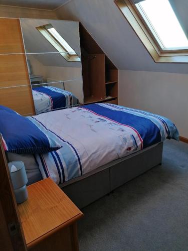2 Betten in einem Schlafzimmer mit 2 Fenstern in der Unterkunft Hytheview Cottage Whitehills in Whitehills